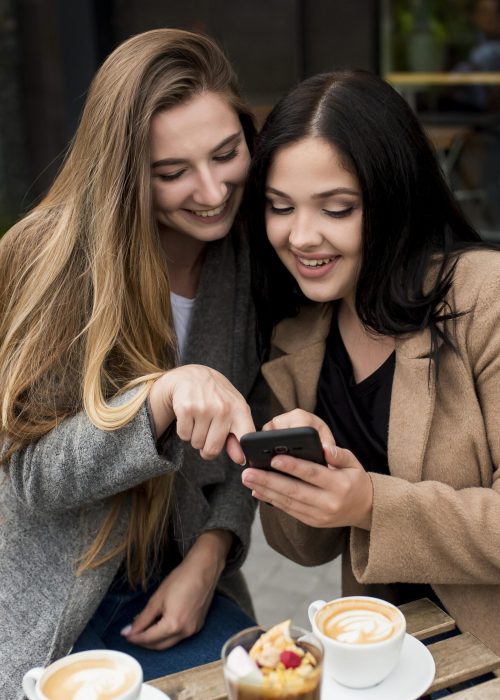 woman-showing-something-her-phone-her-friend
